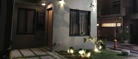 Un edificio moderno de dos pisos con techo plano, ventanas amplias y una entrada bien iluminada.