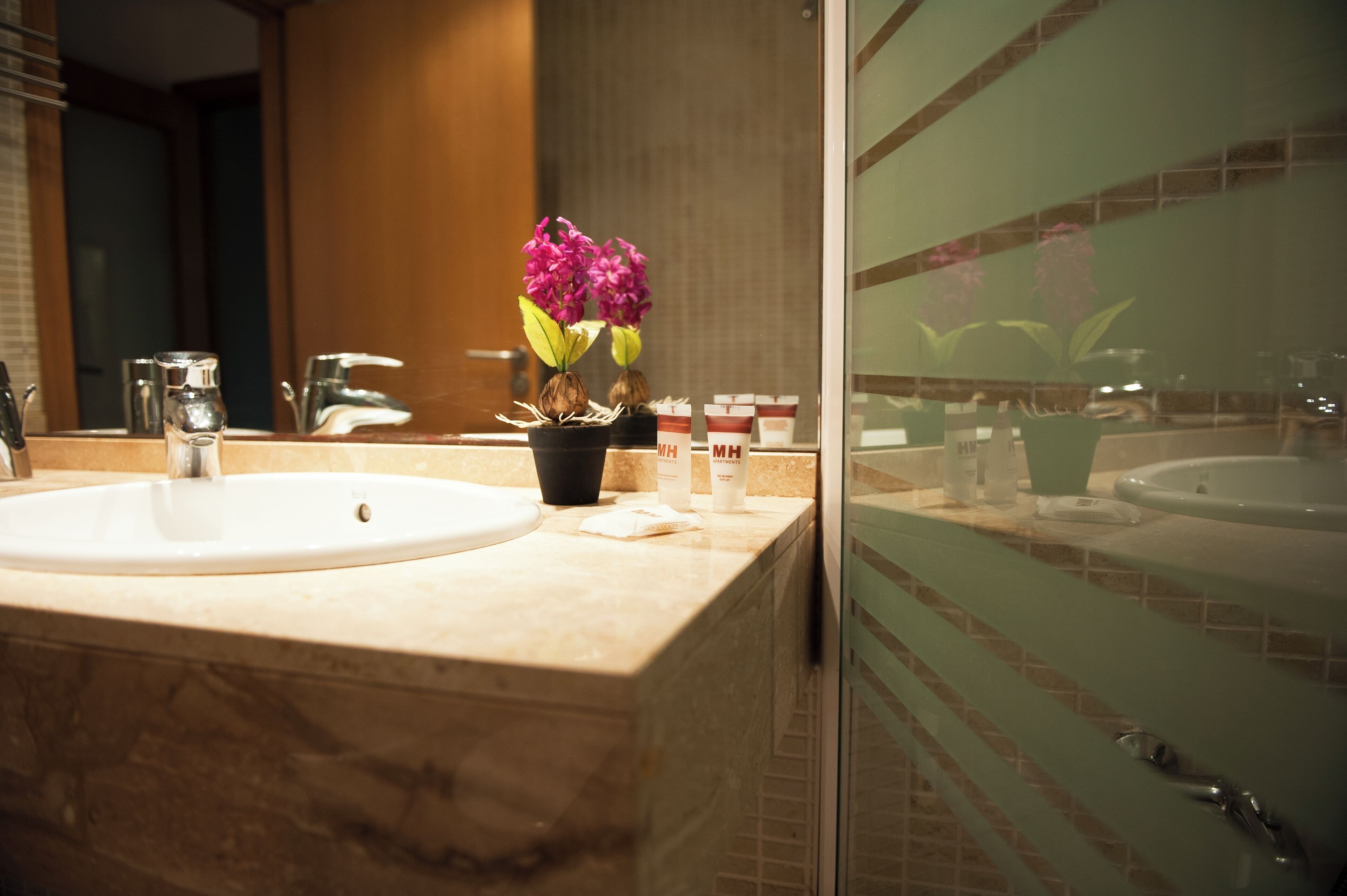 Een aparte badkuip en douche, een haardroger, handdoeken, zeep