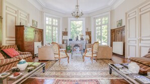 A spacious living room with a fireplace, two armchairs, a sofa, and a coffee table. - Château d'Avesnes Le Castelet (Avesnes-en-Bray)