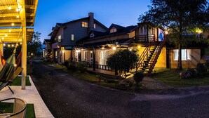 A waterfront property with a hammock, outdoor seating, and a well-lit walkway leading to a house with a deck and stairs. - Dong Shan He B&B (Dongshan)