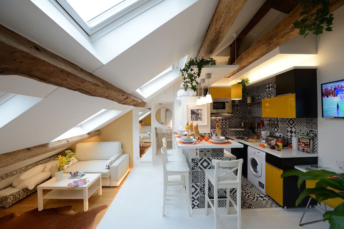 A modern loft apartment with a kitchen, dining area, and living space.