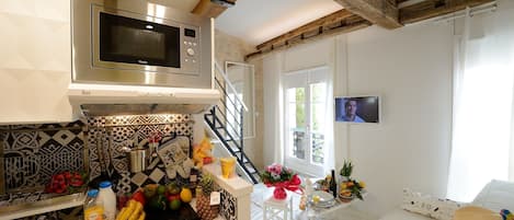 A modern kitchen with a microwave, a sink, and a dining area with a table set for two.