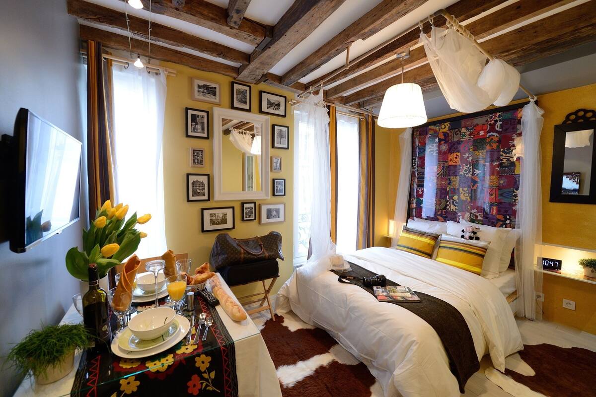 A bedroom with a bed, bedside table, and a window with curtains.