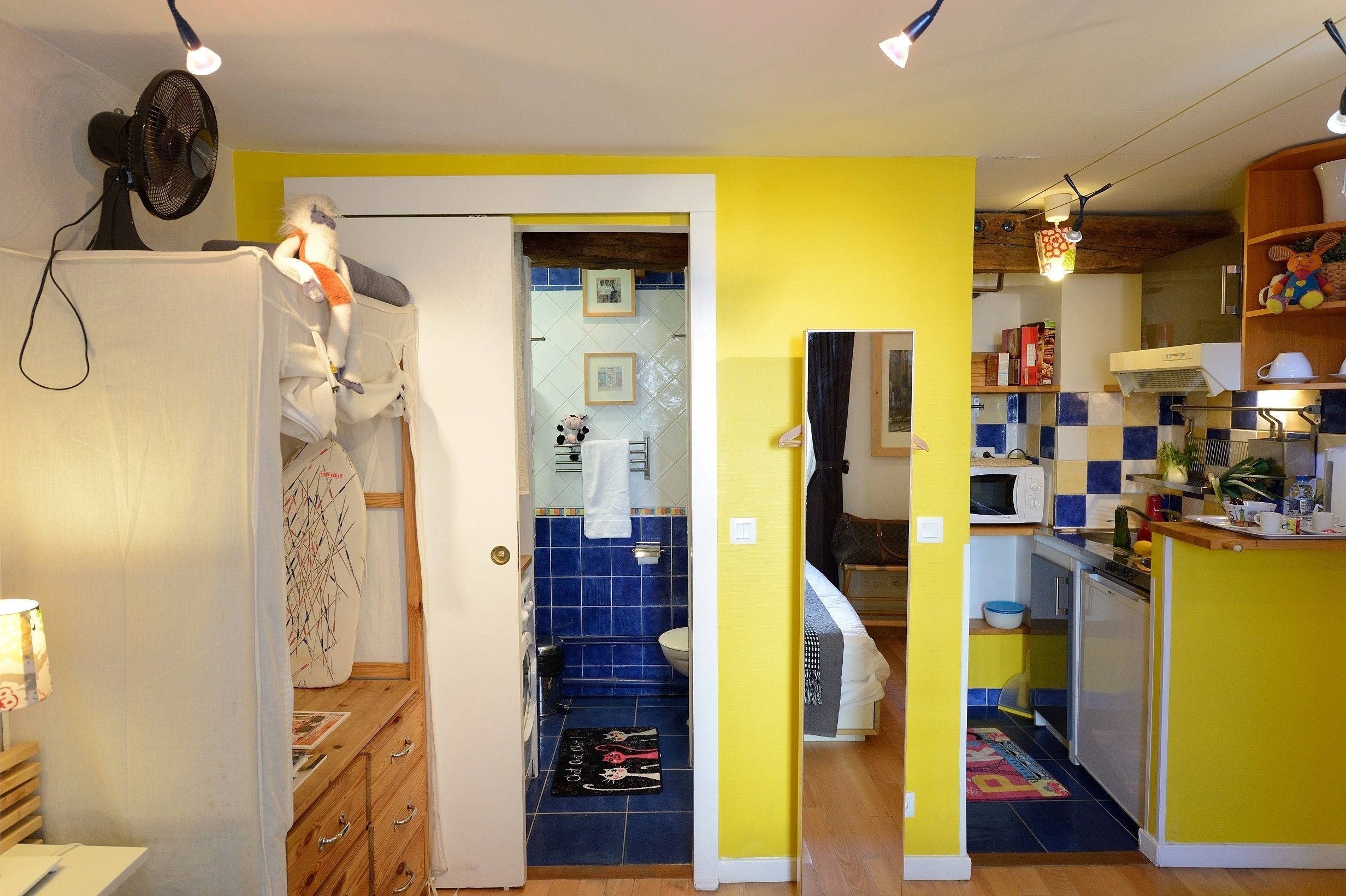 A compact kitchen with a microwave, sink, and wooden cabinets.