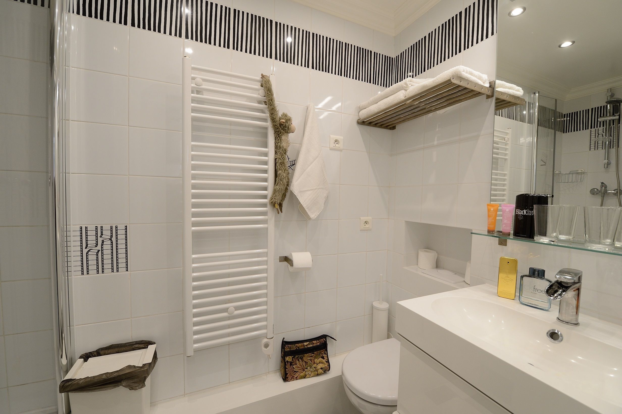 Un baño moderno con cabina de ducha de vidrio, un lavabo blanco y un espejo sobre él.