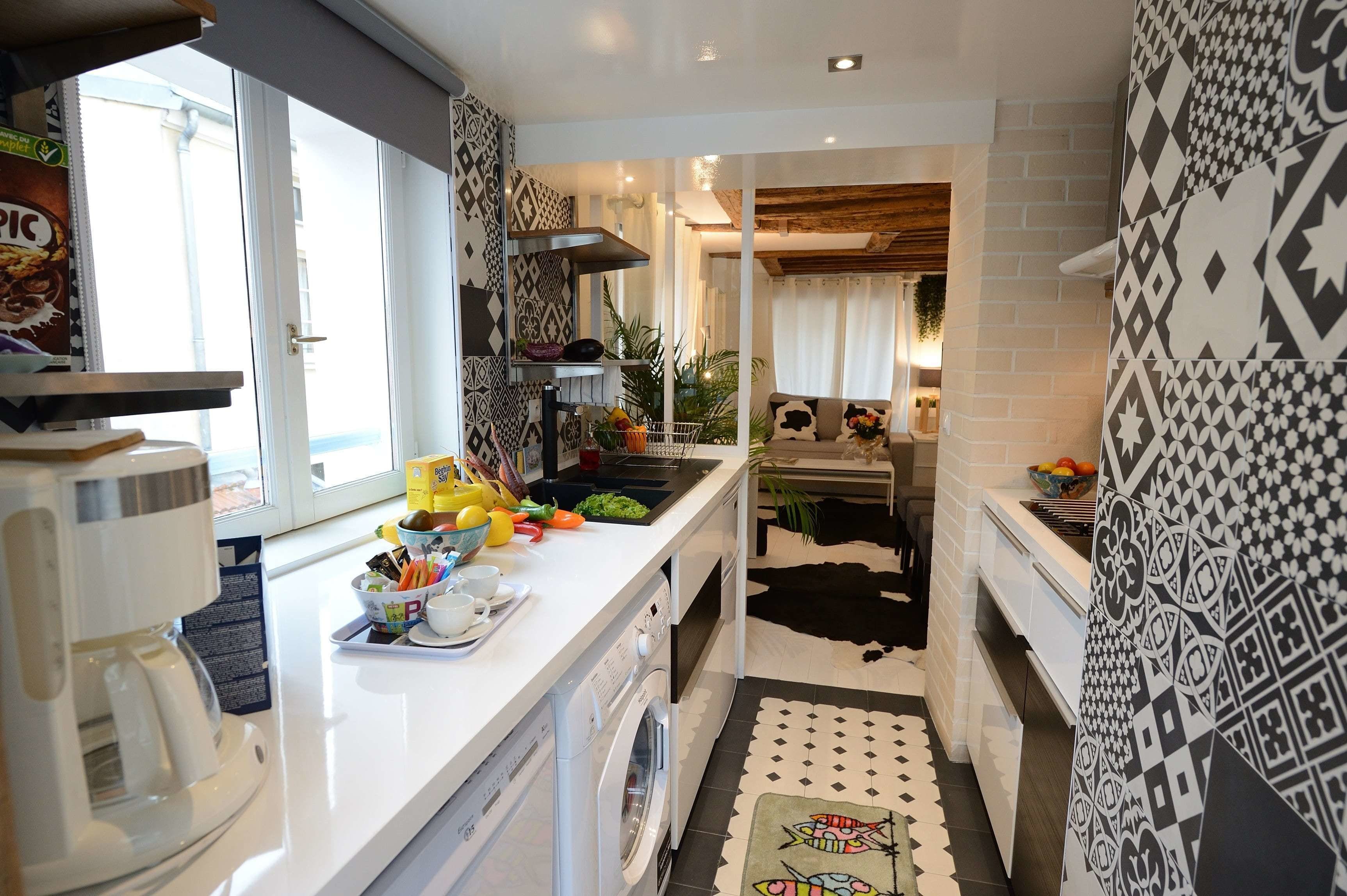 Cocina compacta con cafetera, lavadora y lavaplatos.