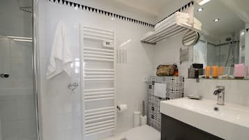 Un bagno moderno con cabina doccia in vetro, un water bianco e un mobile lavabo con specchio.