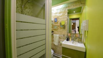 A bathroom with a shower, toilet, and sink.