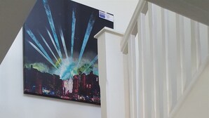 Un escalier avec une peinture représentant un paysage urbain sur le mur.