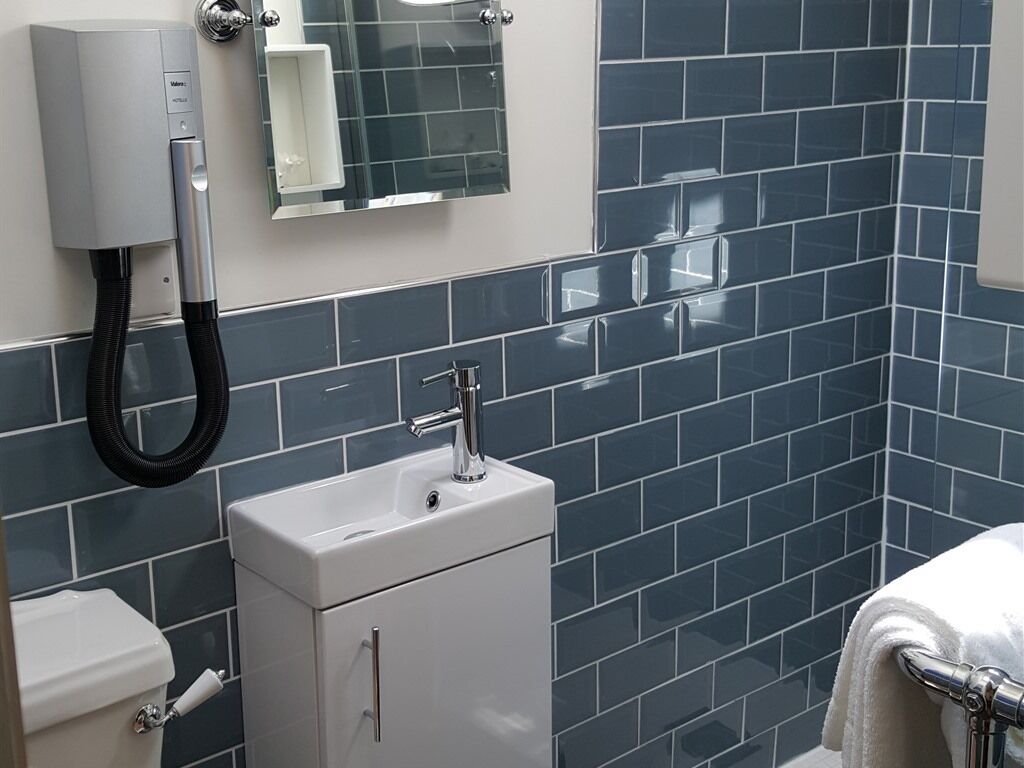 A bathroom with a white sink, a toilet, and a towel rack.