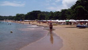 Une plage avec des parasols et des gens.