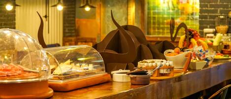 A buffet counter with various food items and a decorative centerpiece.