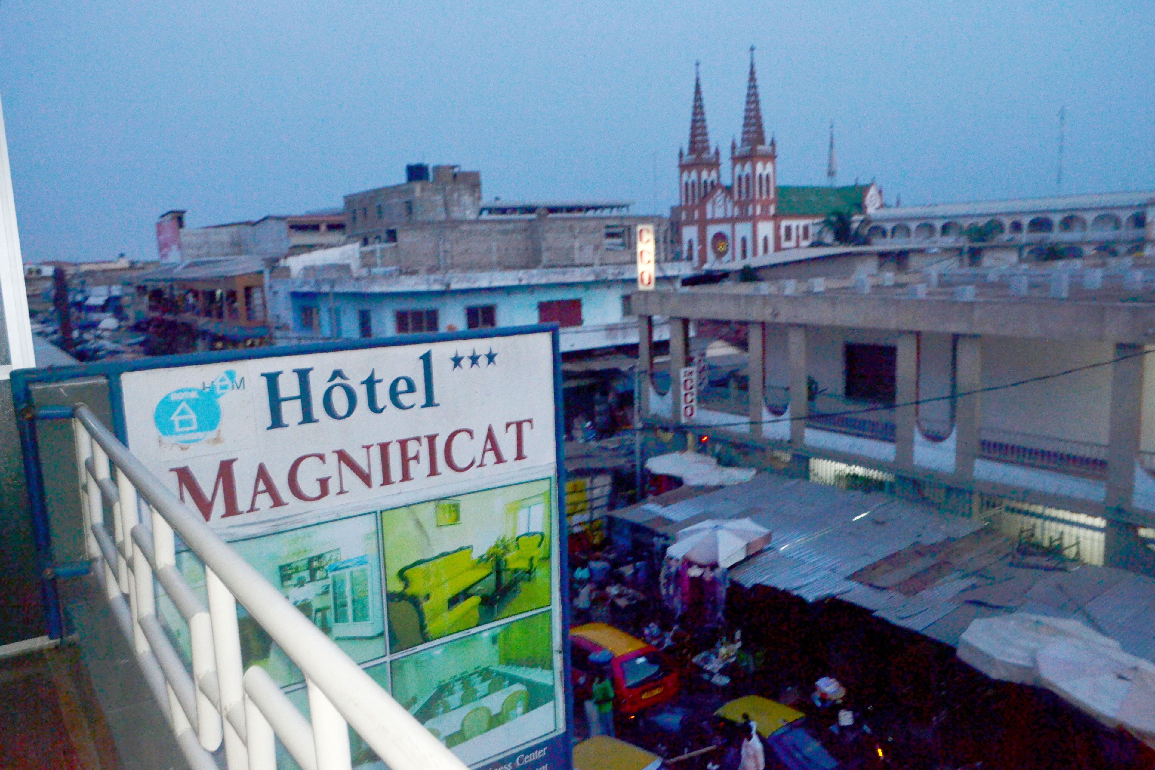 A hotel sign with multiple rooms and a view of a cathedral in the background.