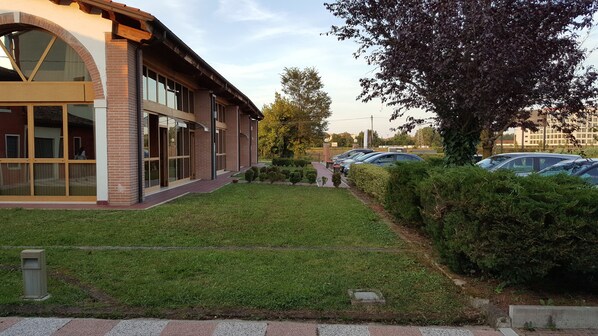 A building with a brick facade, large windows, and a well-maintained lawn.