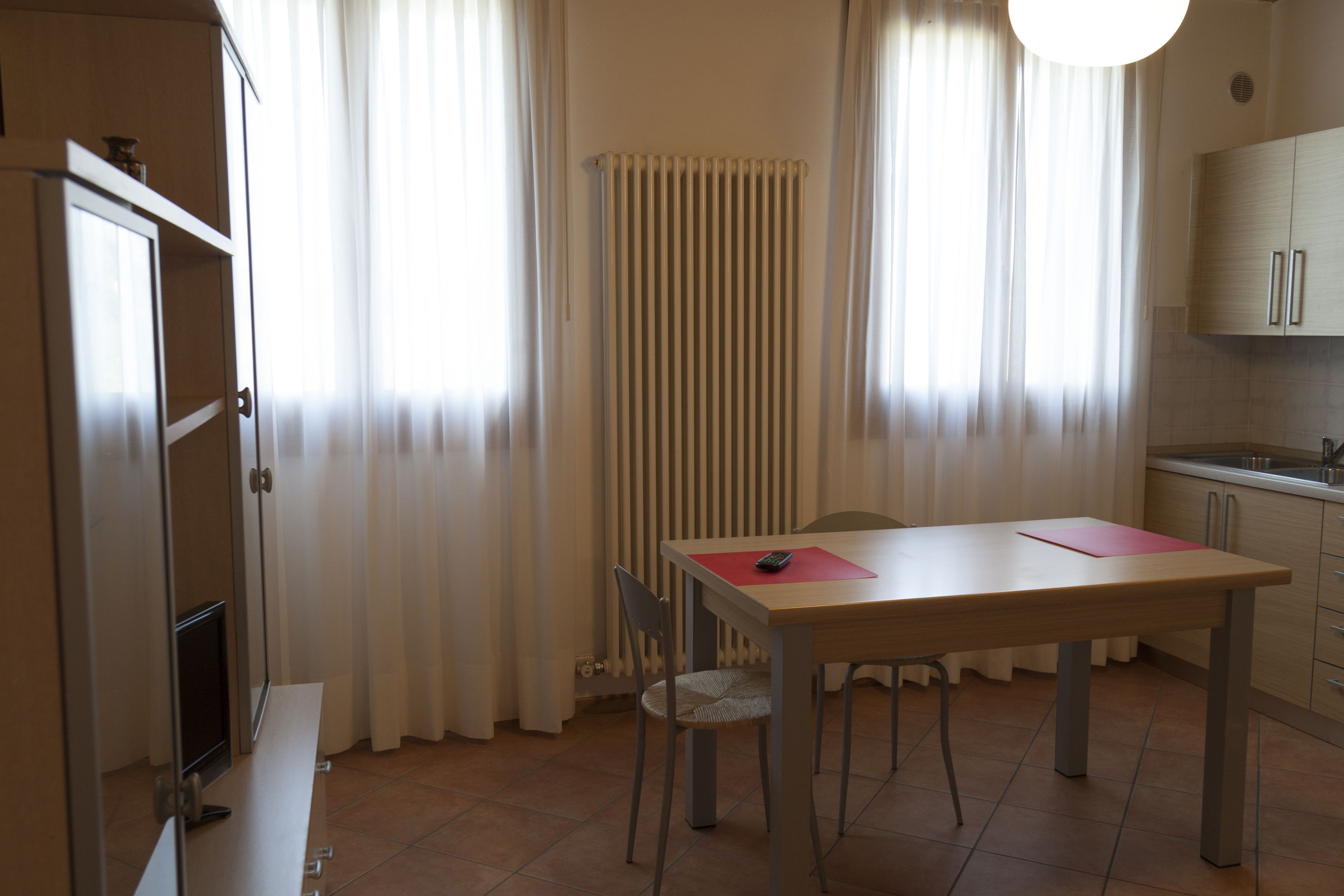 Una cocina moderna con una mesa de comedor, sillas y un horno empotrado.