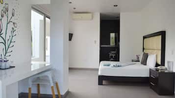 A modern bedroom with a bed, bedside table, and a desk with a chair.