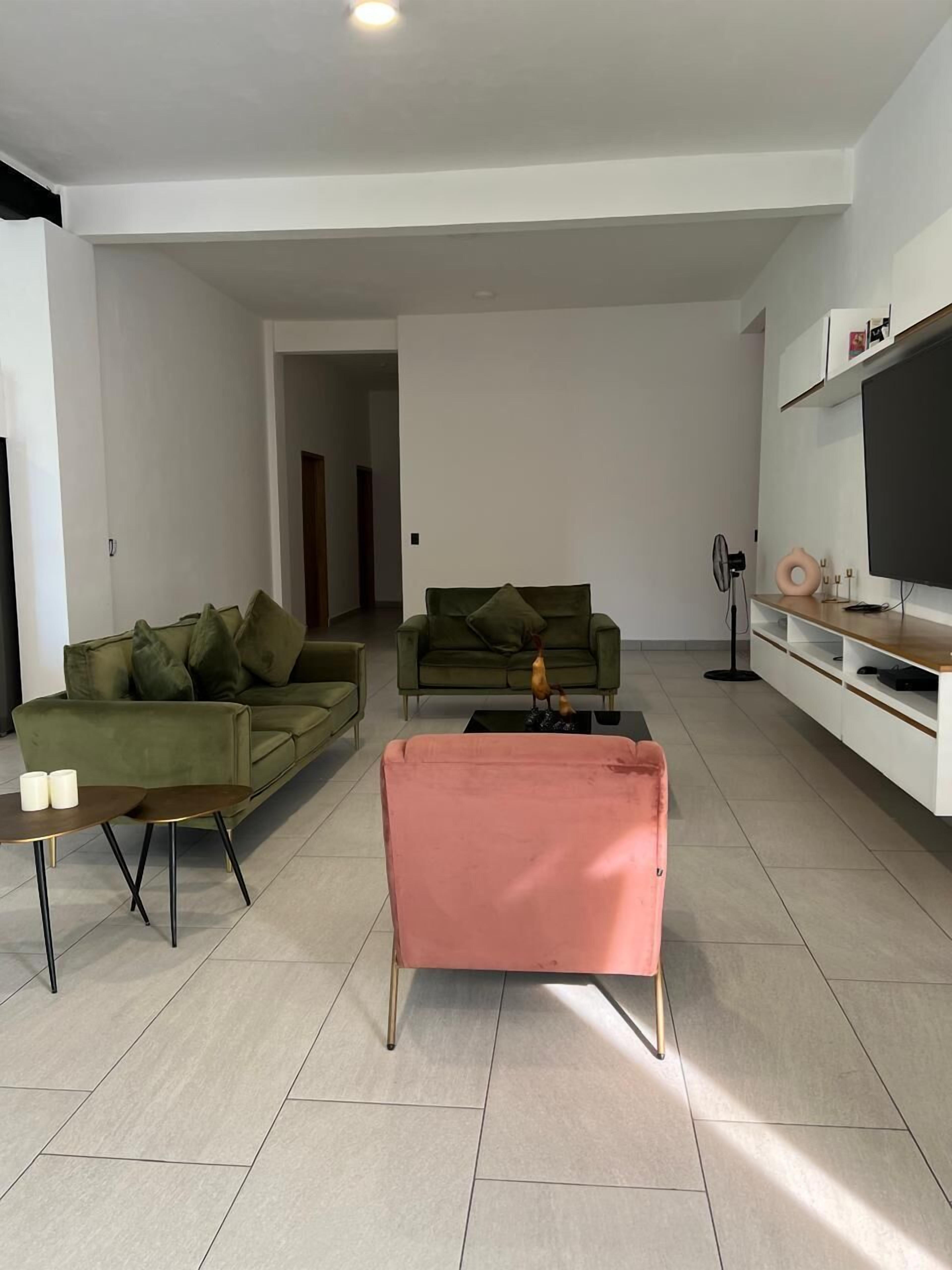 A modern living room with two sofas, a coffee table, and a TV stand.