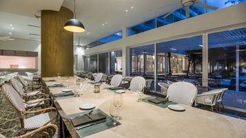 Un comedor amplio con techos altos, ventanas grandes y vistas al exterior.