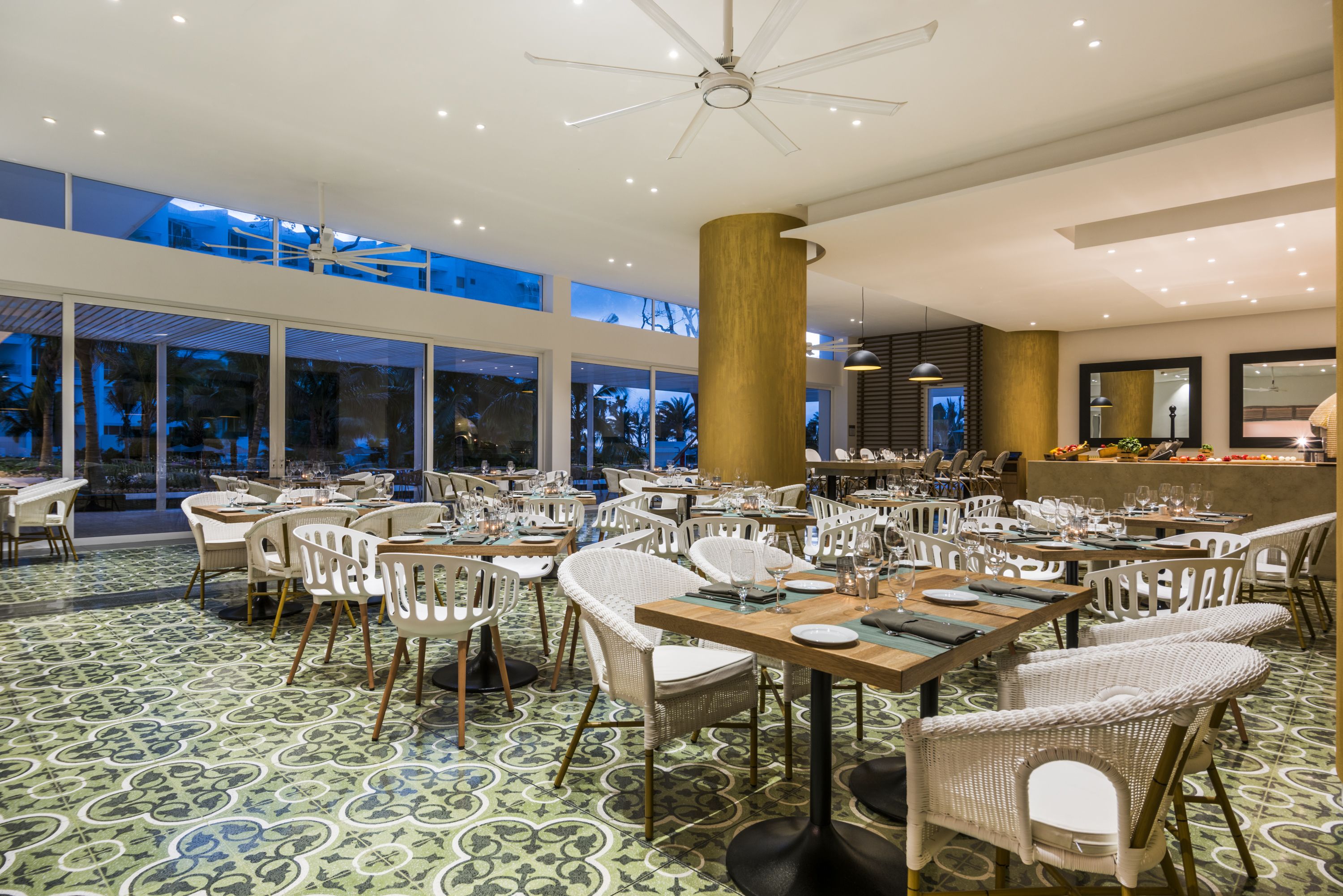 A spacious dining area with high ceilings, large windows, and a modern chandelier.