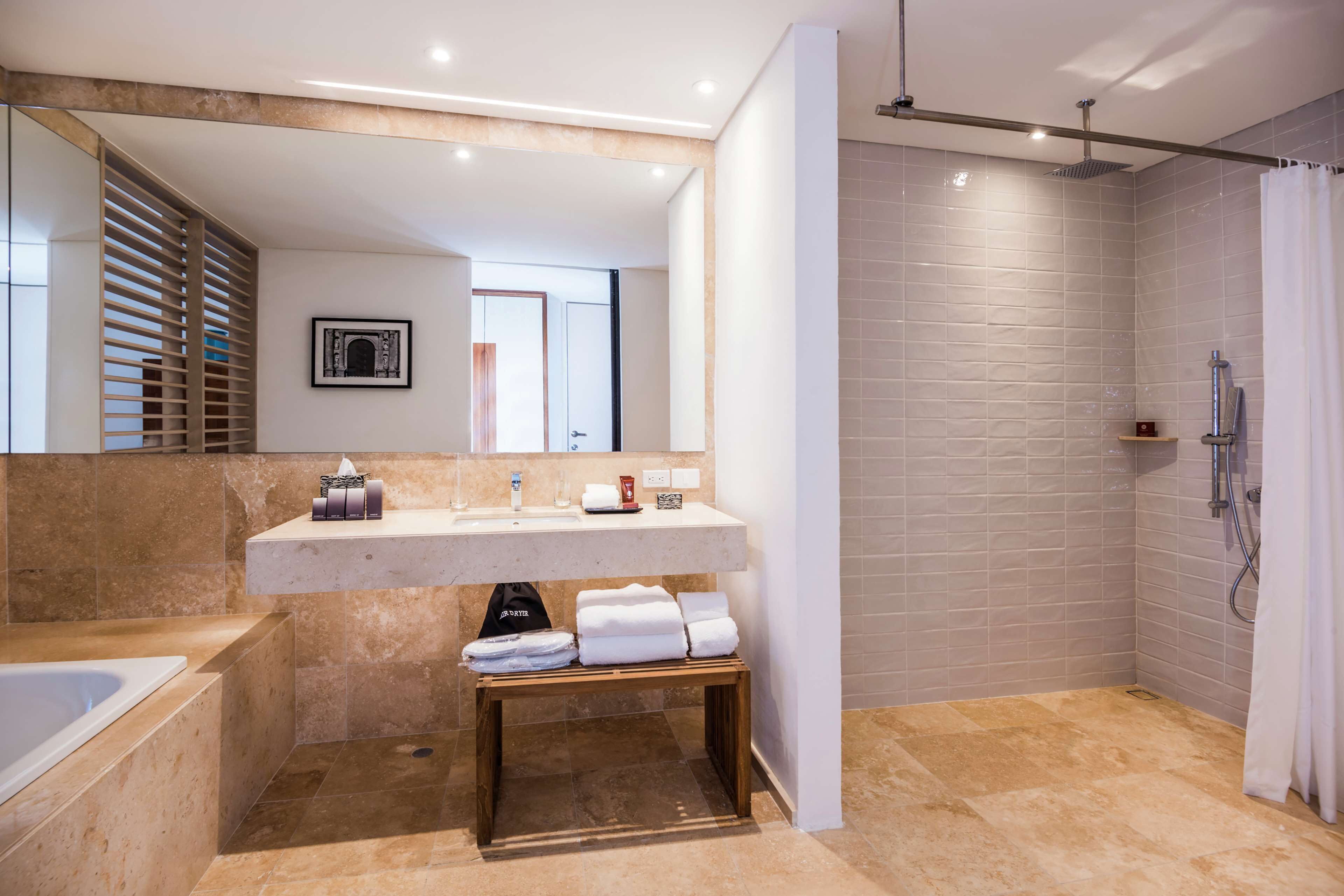 Un baño moderno con bañera, lavabo con toallero y zona de ducha.