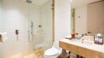 Une salle de bain moderne avec une douche à parois de verre, des toilettes blanches et un sol carrelé en marbre.