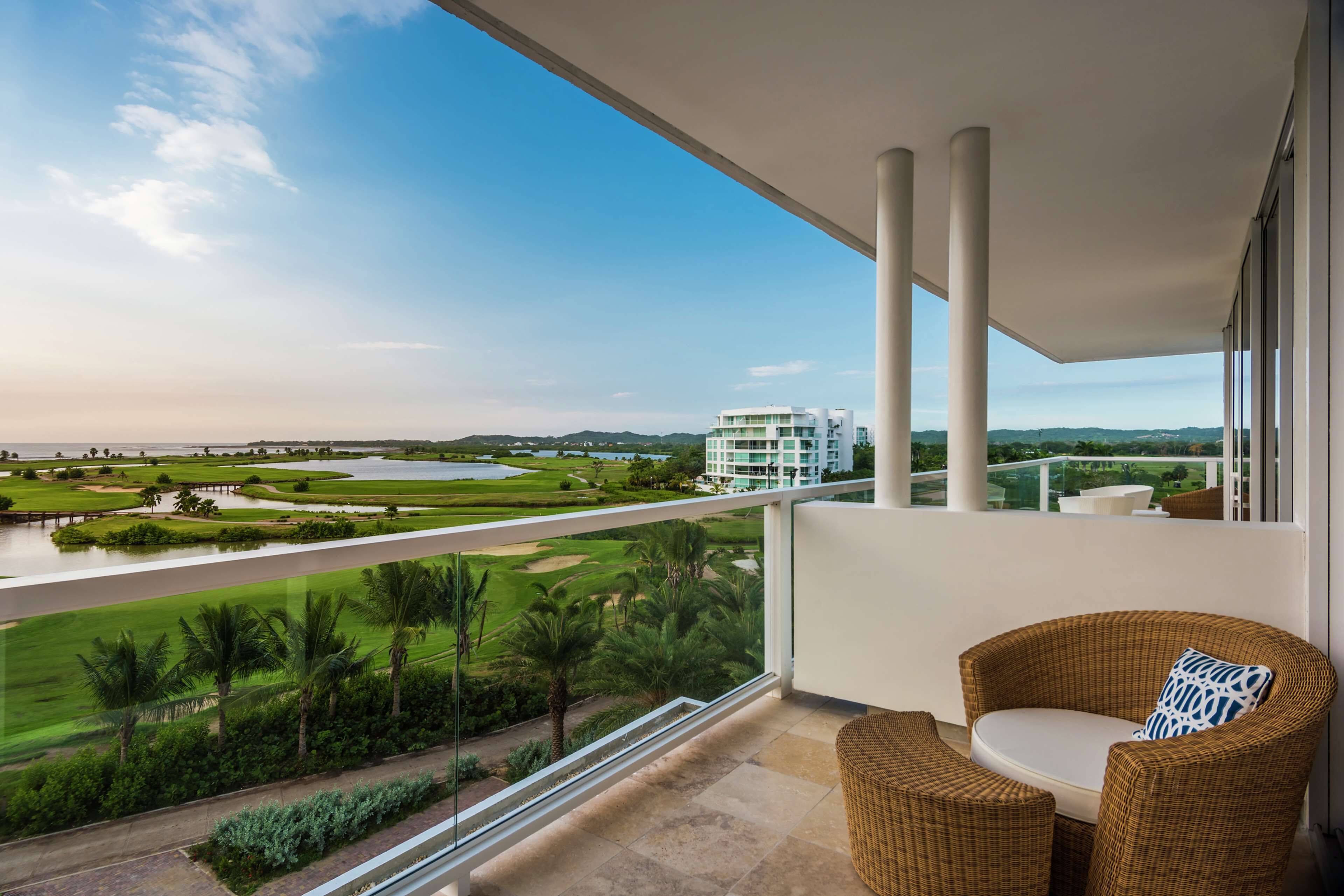 Un balcón con vistas a un campo de golf y un edificio moderno.
