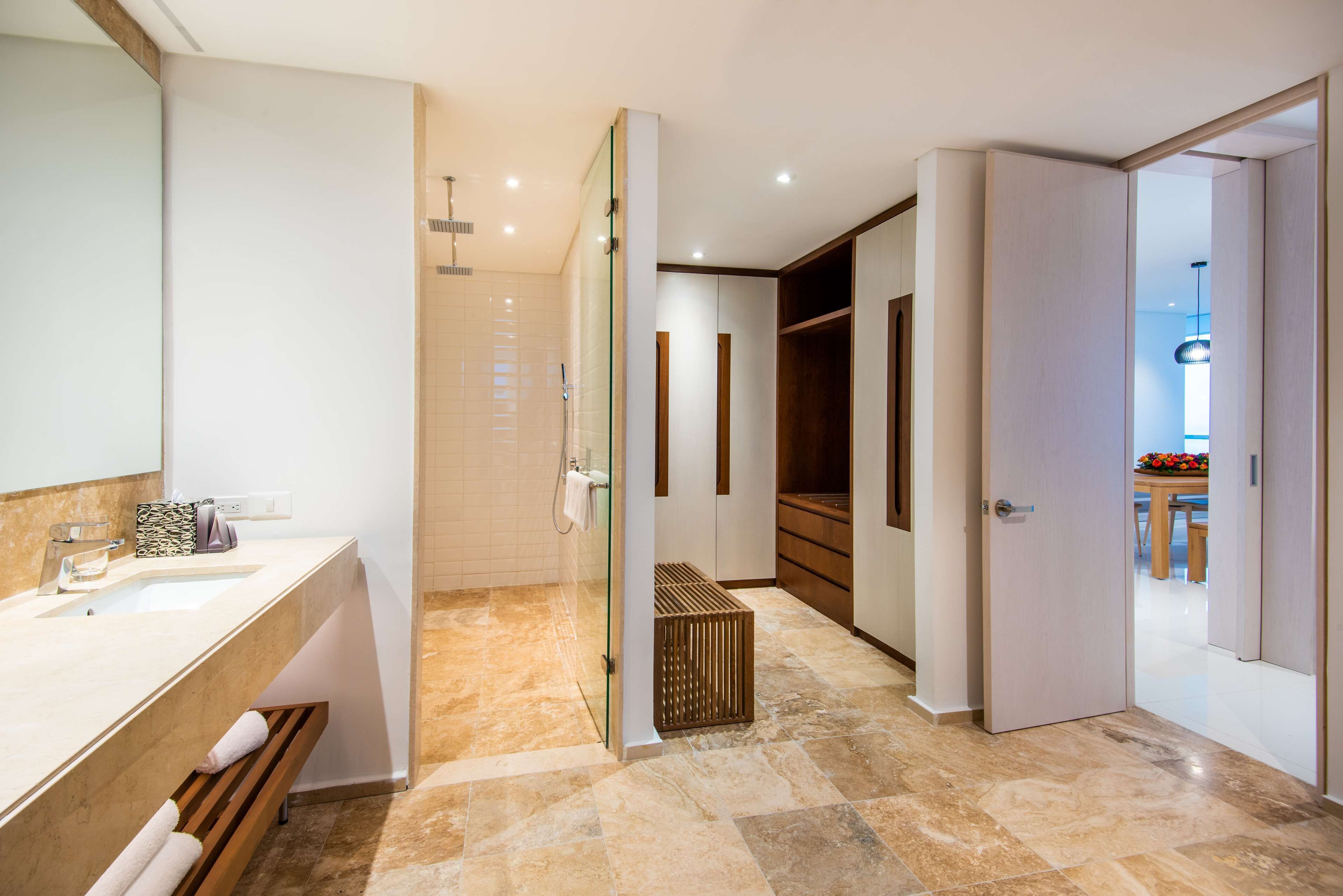 A modern bathroom with a large mirror, a sink, and a shower area.