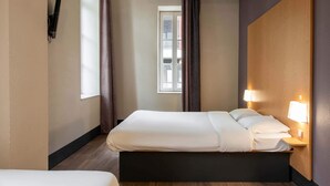 A hotel room with a bed, bedside lamps, a window, and a view of the outside. - B&B HOTEL Castres Centre Gambetta (Castres)