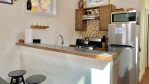 A modern kitchen with a central island, stainless steel appliances, and a wooden backsplash. - Lawson Adventure Park (Idaho Springs)