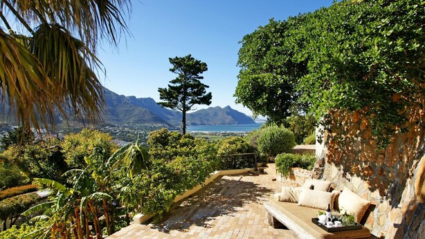 A patio with a view of mountains and a body of water.