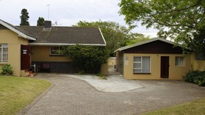 Ein zweistöckiges Haus mit einer gepflasterten Auffahrt zu einem verschlossenen Eingang.