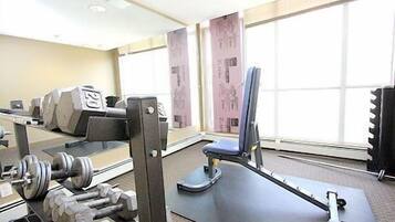 A gym with exercise equipment, a weight bench, and a rowing machine.