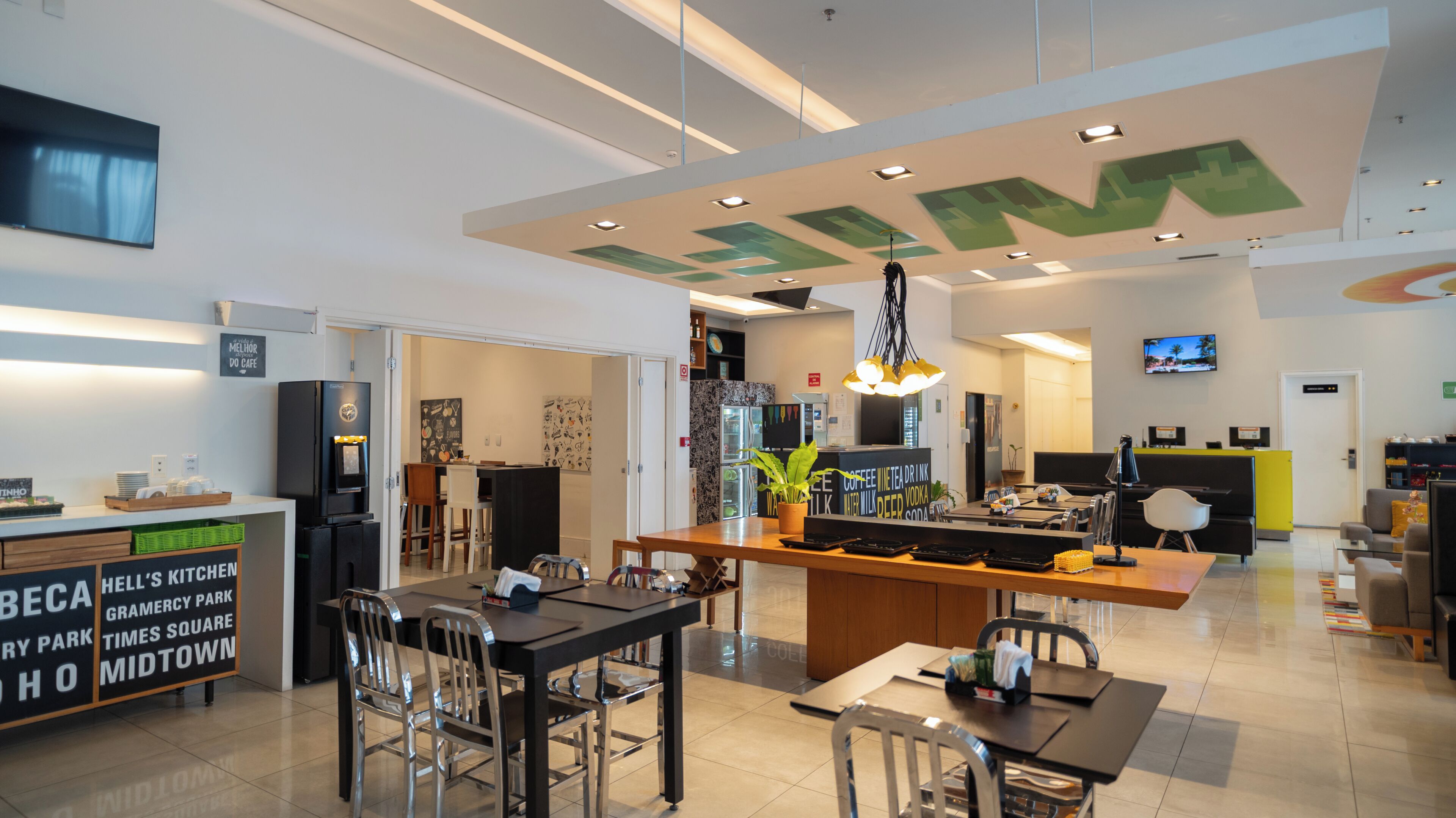 Una cafeteria moderna amb zona de bar, seients i mostrador de cuina.