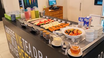 Un bufé con diversas opciones de comida y bebidas.