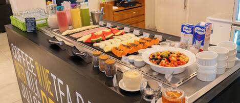 A buffet with various food items and beverages.