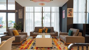 Eine moderne Hotelhalle mit zwei Sofas, einem Couchtisch und einem gemusterten Teppich.