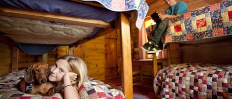 A cabin with wooden walls and bunk beds.