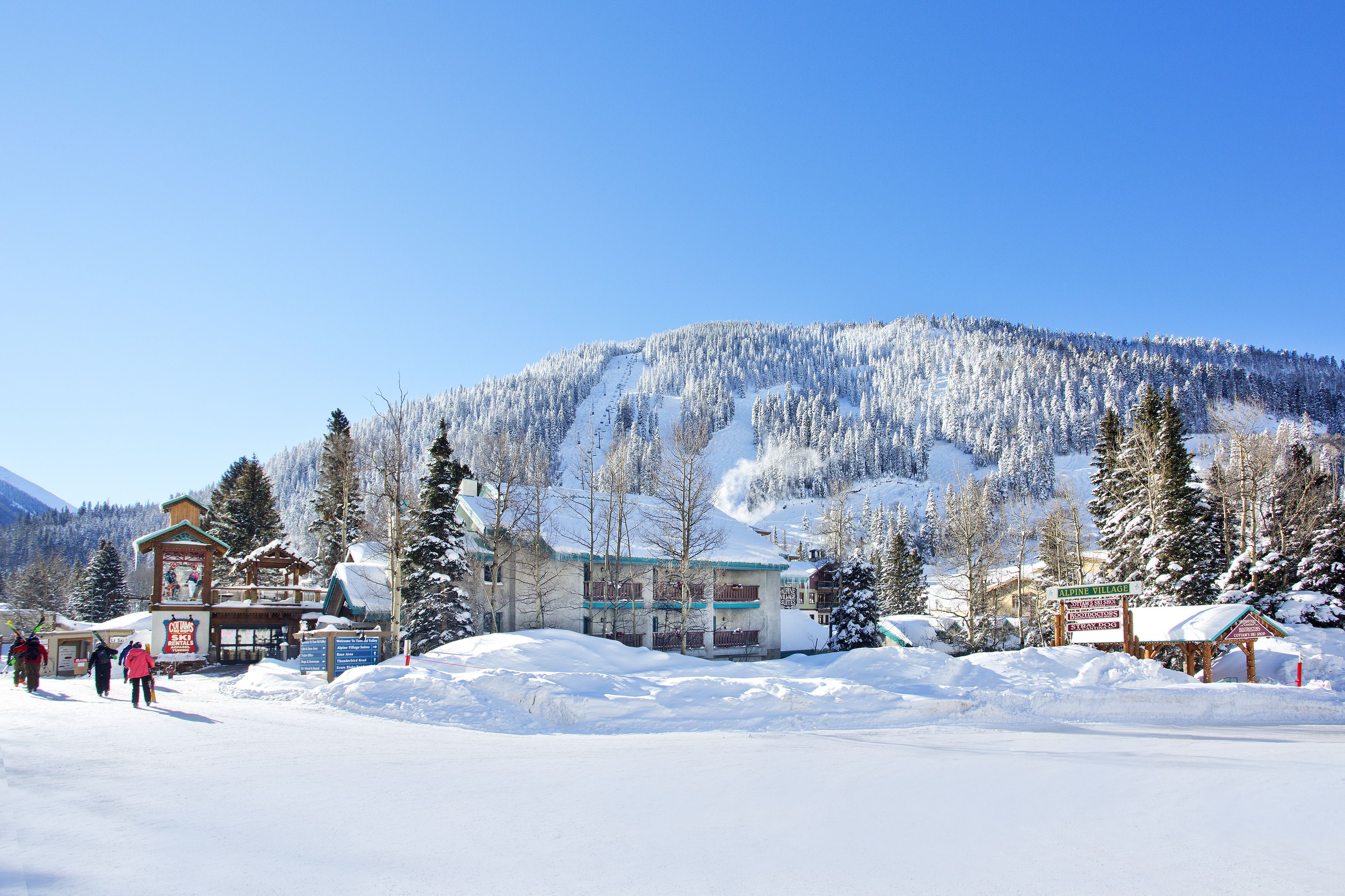 Een bergstad bedekt met sneeuw, met gebouwen en een skigebied.