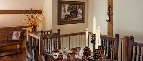 A dining table set with candles, plates, and glasses.