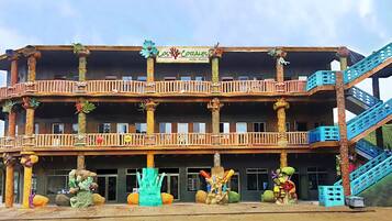 Experience the unique architectural style of Los Corales Hotel, featuring a central atrium and balconies adorned with tropical motifs.