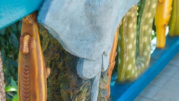 Barandilla azul con una escultura de cabeza de tiburón y esculturas de peces.