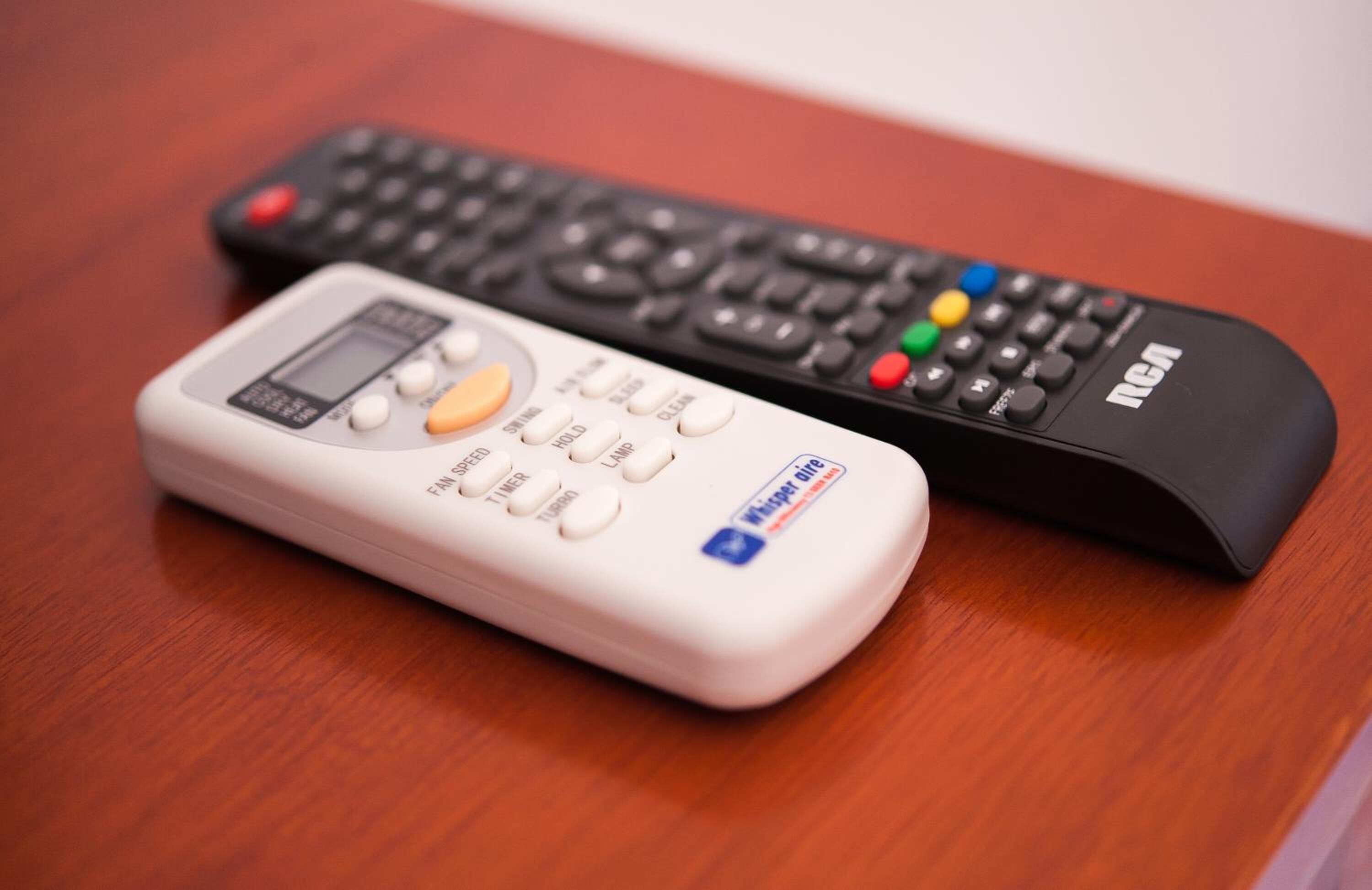 Two remote controls on a wooden surface.
