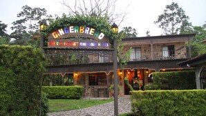 Hotel Boutique Gingerbread Fine Restaurant, com um caminho de pedra que leva à entrada, rodeado por vegetação.