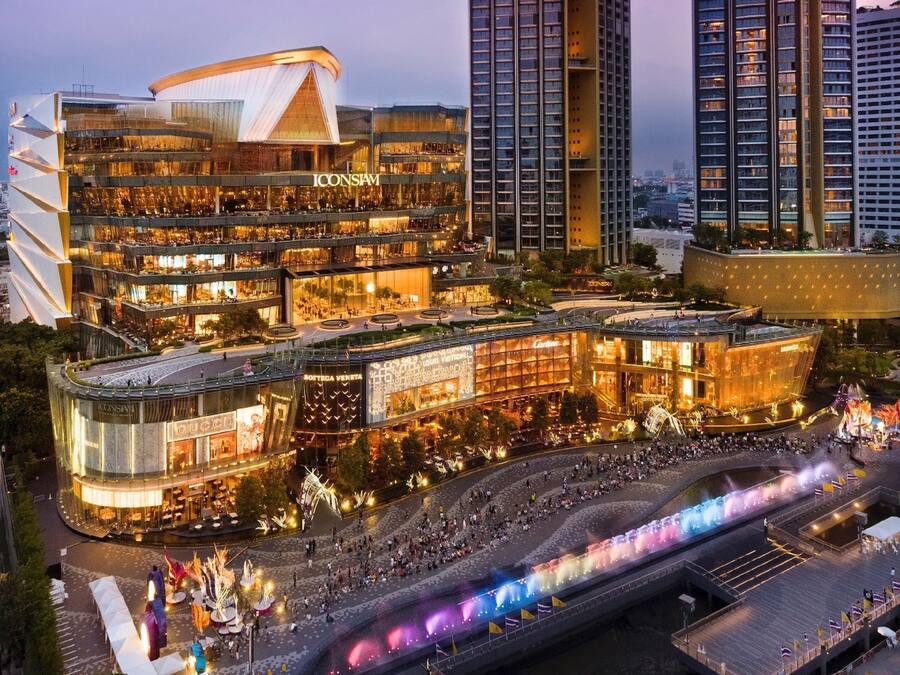 A multi-story hotel with a curved facade, multiple retail spaces, and a central courtyard with a fountain.