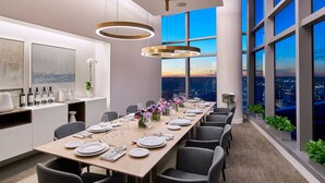 A modern conference room with a long table set for a meeting, large windows offering a city view, and contemporary lighting fixtures. - AKA University City (Philadelphia)