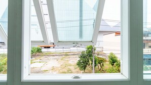 Une vue à travers une fenêtre, avec un bâtiment moderne en arrière-plan.