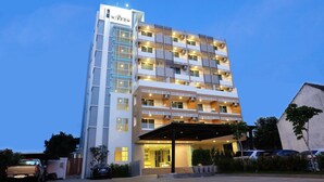 A multi-story hotel with a modern design, featuring a prominent entrance and a covered outdoor area. - Wisdom Residence (Hat Yai)