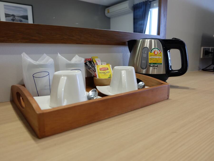 A tray with cups, a Lipton tea packet, and a teapot on a hotel table.