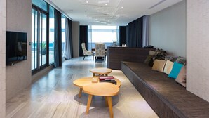 A modern hotel lobby with a reception desk, seating area, and large windows offering a view. - All-Ur Boutique Motel - Xin-Jhung Branch (New Taipei City)