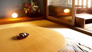 Una habitación tradicional japonesa con tatami, una mesa baja y un plato de mochi.